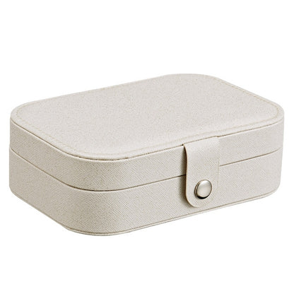 Portable jewelry storage box in light beige with hinged lid and clasp front.