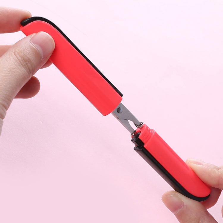 Red folding mini scissors with black blade, held open with safety guard