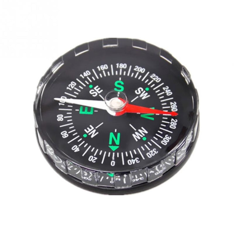 Black round mini compass with green direction letters and red needle, clear dial rim
