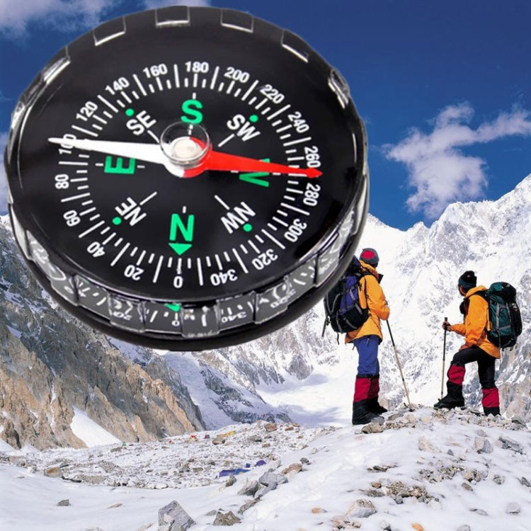 Black mini compass with green N/S markers and red needle, portable navigation tool