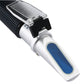 Close-up handheld refractometer with blue lens window and textured black grip