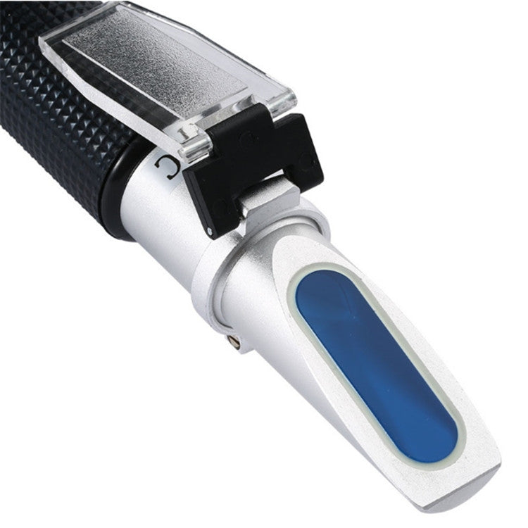 Close-up handheld refractometer with blue lens window and textured black grip