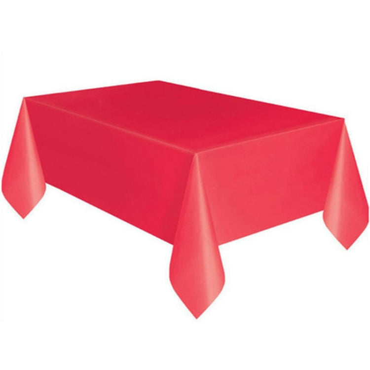 Disposable plastic tablecloth in solid red, rectangular with draped corner hanging drops.