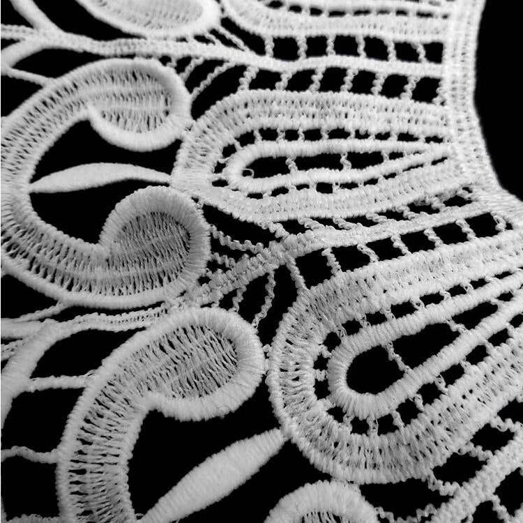 White lace embroidered fake collar close-up showing intricate swirl cutwork