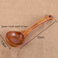 Long-handled wooden cooking spoon with shallow oval bowl and end hole