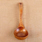 Upright wooden spoon with oval bowl and small hole at the handle end