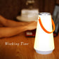 Glowing white rechargeable LED table lamp with orange handle and silver top