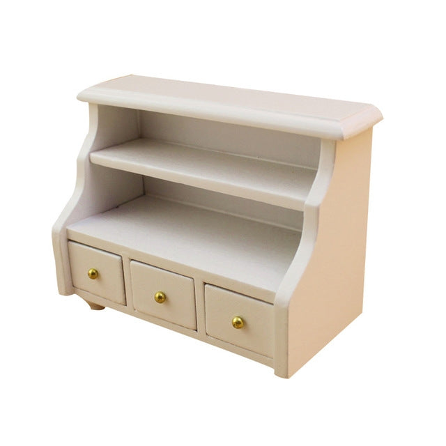 White mini bathroom cabinet with open shelf top and three drawer fronts, gold knobs