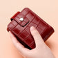 Red croc-pattern lipstick storage bag with buttoned flap and top handle loop