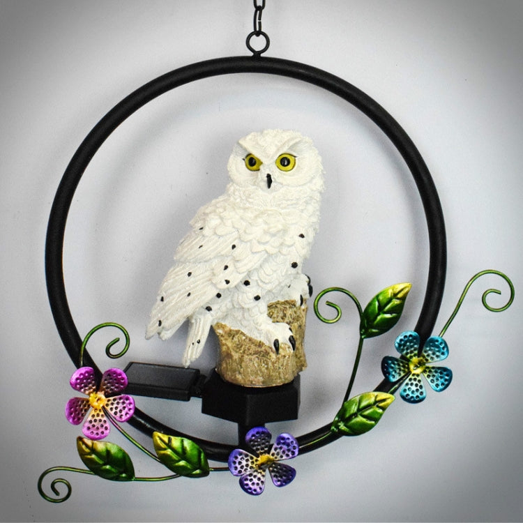 Hanging solar owl garden LED light with white owl figure and black base, floral vines