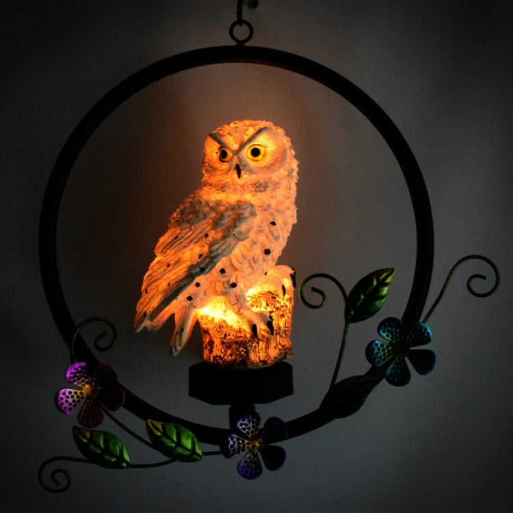 Lit hanging solar owl garden LED light with orange glowing owl figure in black ring