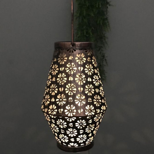 Hanging metal lantern with floral cutout sides and arched top handle