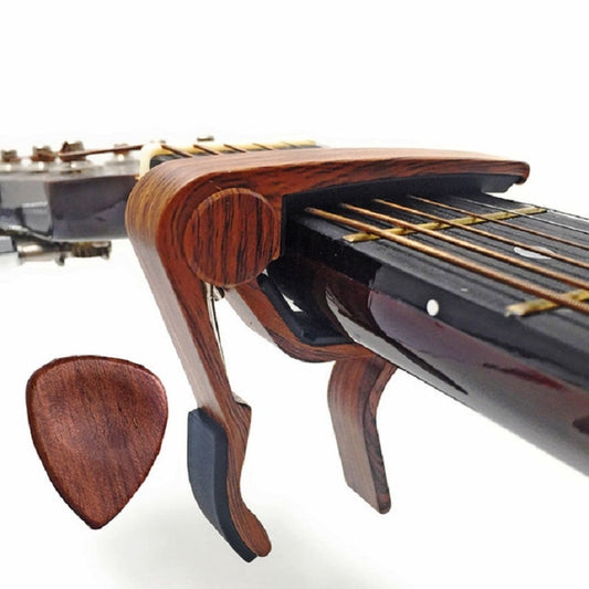 Wood guitar capo with black grip and three wooden pick plectrums