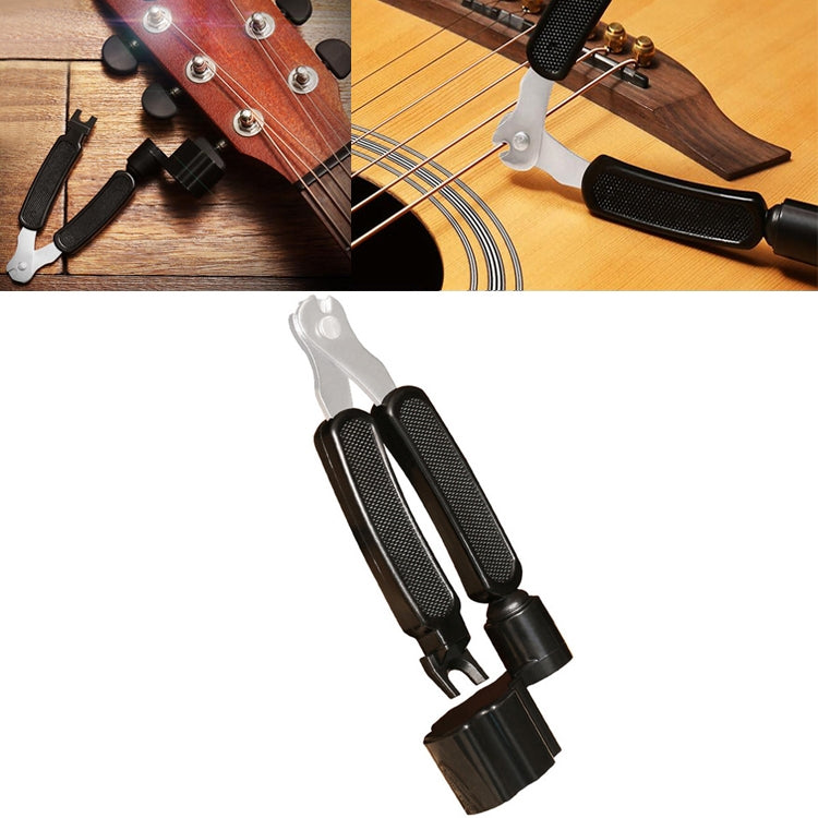 Guitar string changing tool set with clamp, winder handle, and cutter tools on guitar headstock