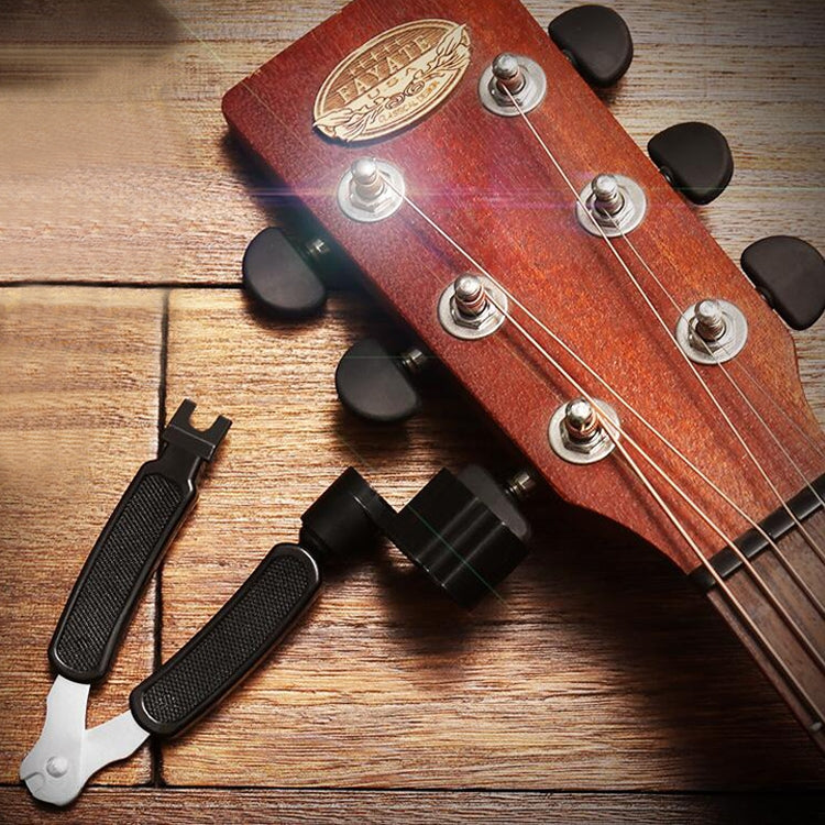 Guitar string changing tool set with two black-handled tools and clamps on guitar