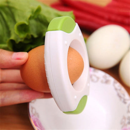 White egg opener with green accents and oval blade opening for cracking eggs