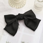 Black satin bow hairpin clip with layered loops and gathered center