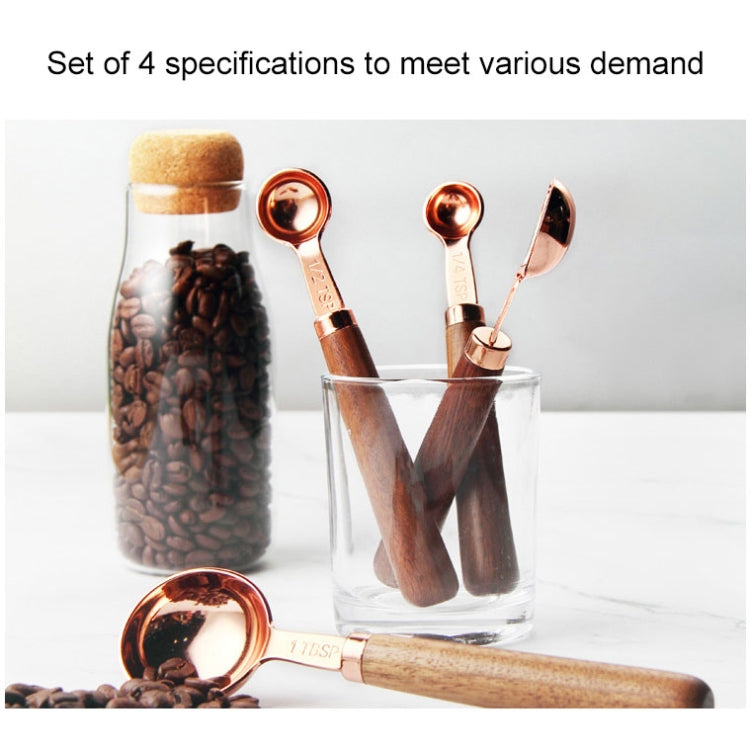 Four-piece copper measuring spoon set with walnut handles, shown in clear container