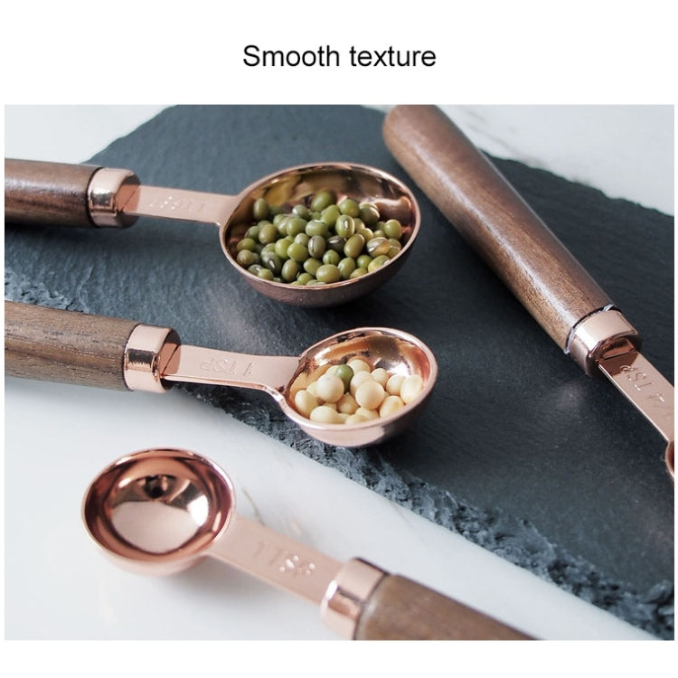 Copper measuring spoons with walnut handles, filled with green peas and pale beans