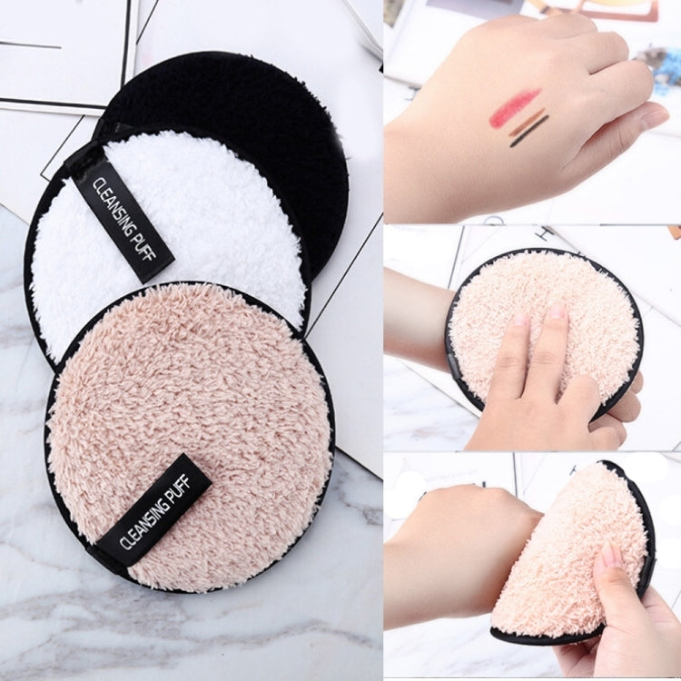 Two circular cleansing puffs in a black case—white and peach microfiber pads.