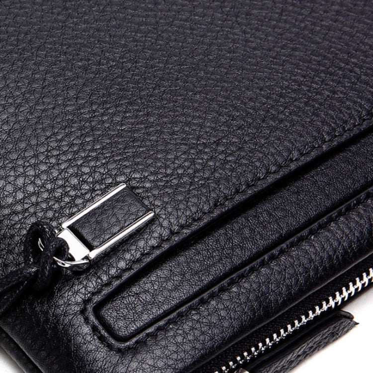 Black leather coin purse close-up of metal clasp and zipper track hardware.