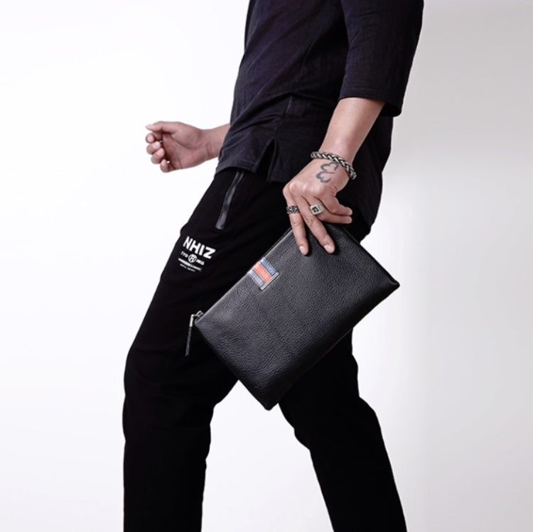 Black leather zip clutch coin purse with wrist strap, carried at side