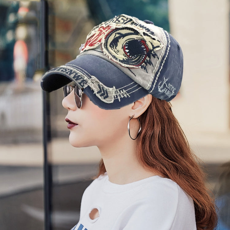Denim and beige baseball cap with embroidered shark front patch and worn brim trim