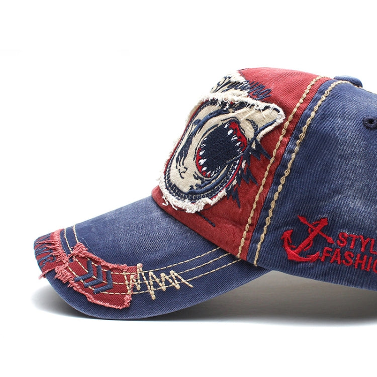 Blue baseball cap with embroidered shark emblem patches and contrast stitching.