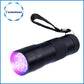 Mini UV flashlight in black with wrist strap, emitting a purple UV glow