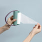 Handheld sticky lint roller brush with mint and white refill, purple loop handle