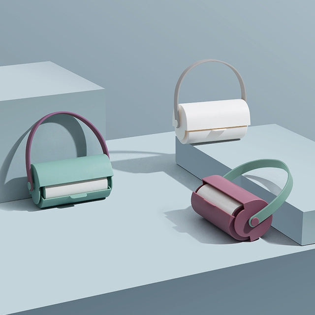 Handheld sticky lint rollers, teal and white units with colored loop handles