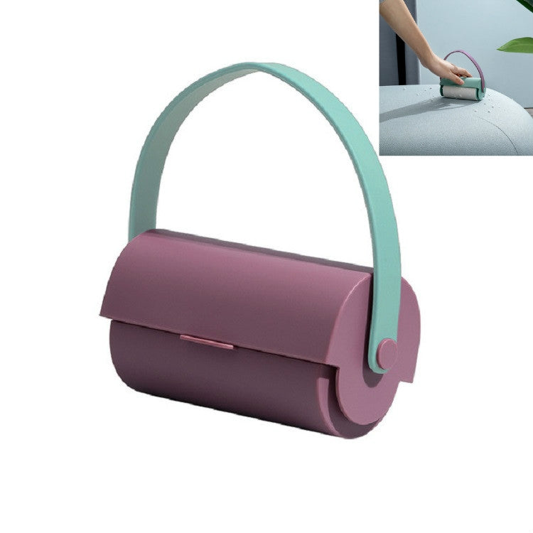 Handheld sticky lint roller with purple body and mint handle ring