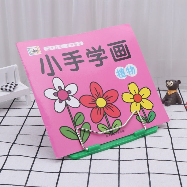 Pink workbook on green metal wire book stand, angled for reading