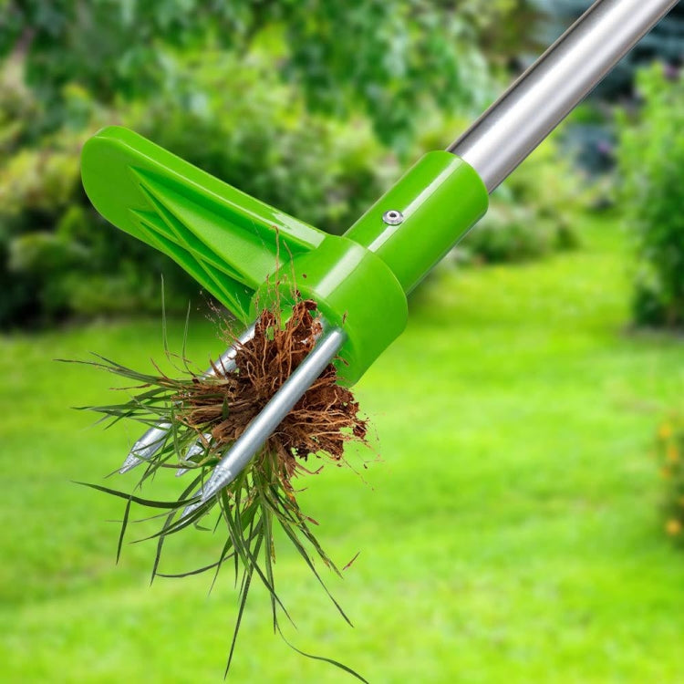 Green weed puller with three prongs gripping uprooted weeds and soil