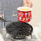 Perforated black heat plate on gas burner supporting a small pot