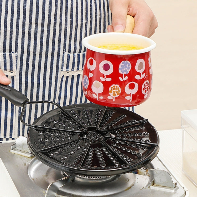 Perforated black heat plate on gas burner supporting a small pot