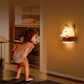 Bear night light wall lamp glowing on wall beside a child