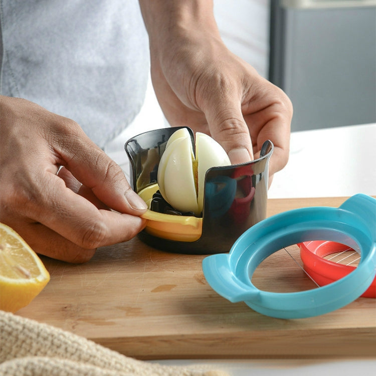 Egg slicer cup with black insert and red ring, holding a sliced hard-boiled egg