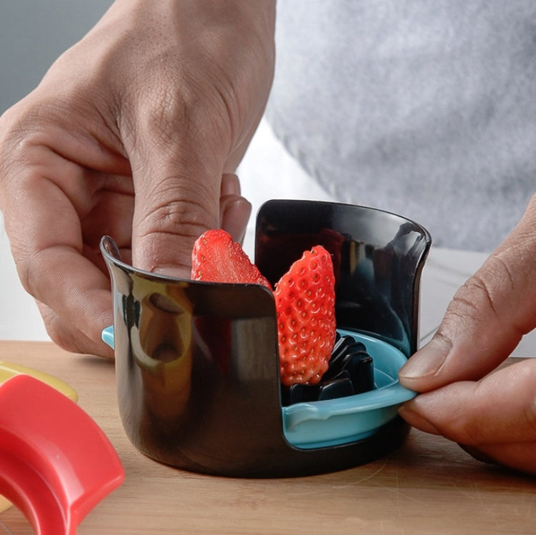 Egg slicer cup with black body and teal insert, holding sliced strawberries