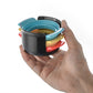 Egg slicer set with black cup, teal lid, and red and yellow parts in hand