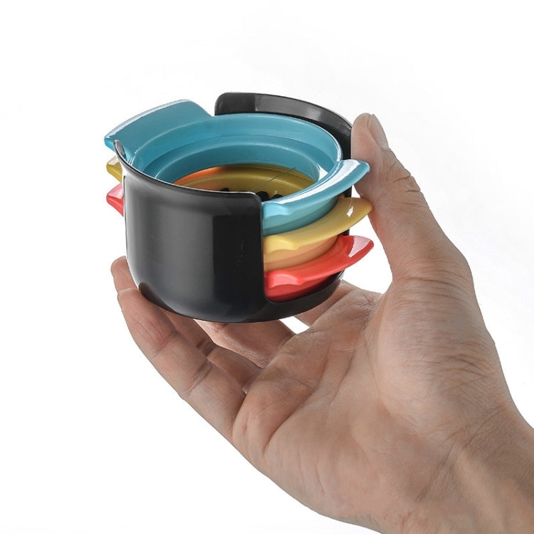 Egg slicer set with black cup, teal lid, and red and yellow parts in hand