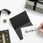 Black and white thank-you card with gold foil border, held by hand, with small star charm