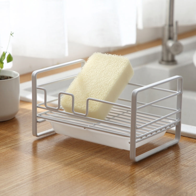 White metal dish drain rack holding a beige sponge on a slotted drying tray