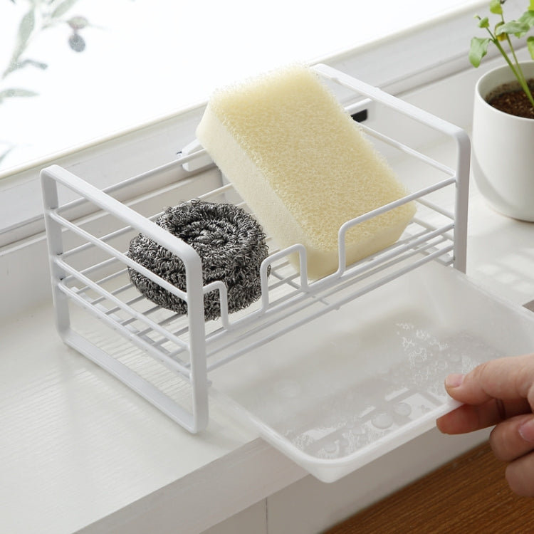 White metal dish drain rack with beige sponge and gray scrubber in front holders