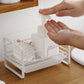 White metal dish drain rack with soap dispenser and brush holders, hands adjusting