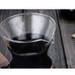Clear top reservoir of a coffee maker on a dark base, shown in close-up