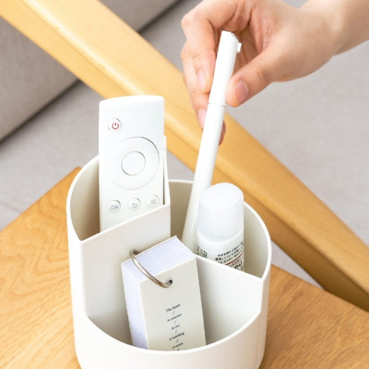 Hand placing a pen into a rotating round pen holder with storage compartments.