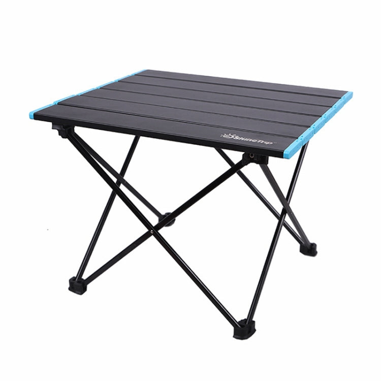 Folding camping table with black slatted tabletop and blue corner edges, X-frame legs
