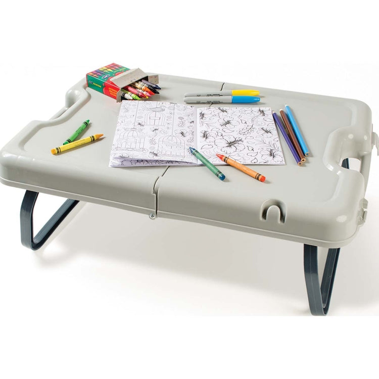 Folding table with legs extended, light gray top with drawing pad and markers