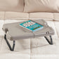 Folding tray table with legs, light gray top with notebook and pen
